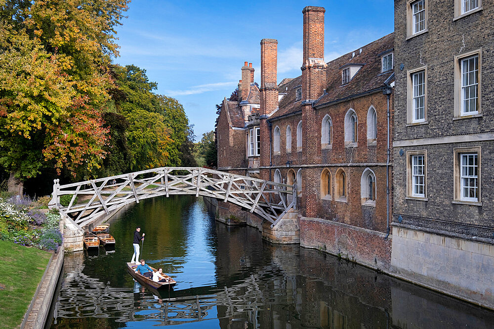 Punting on River Cam under the Mathematical Bridge in autumn, Queens College Cambridge, Cambridge, Cambridgeshire, England, UK