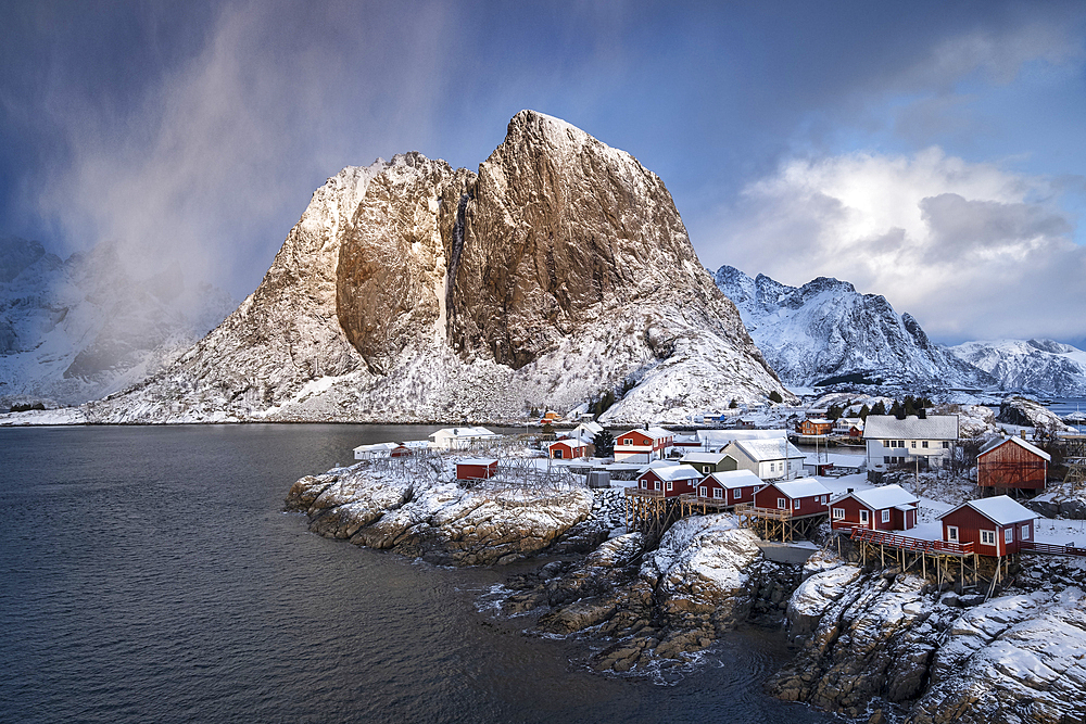 Red Norwegian Rorbuer Huts and Festhaeltinden mountain in winter, Hamnoy, Moskenes Municipality, Nordland County, Lofoten Islands, Norway, Scandinavia, Europe