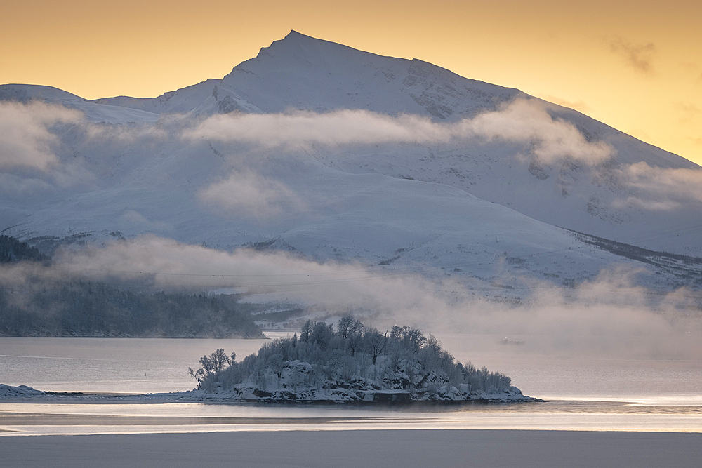 Holman Island in Ramfjorden backed by the peak of Haugafjellet mountain at sunset, near Tromso, Troms og Finnmark county, Norway, Scandinavia, Europe