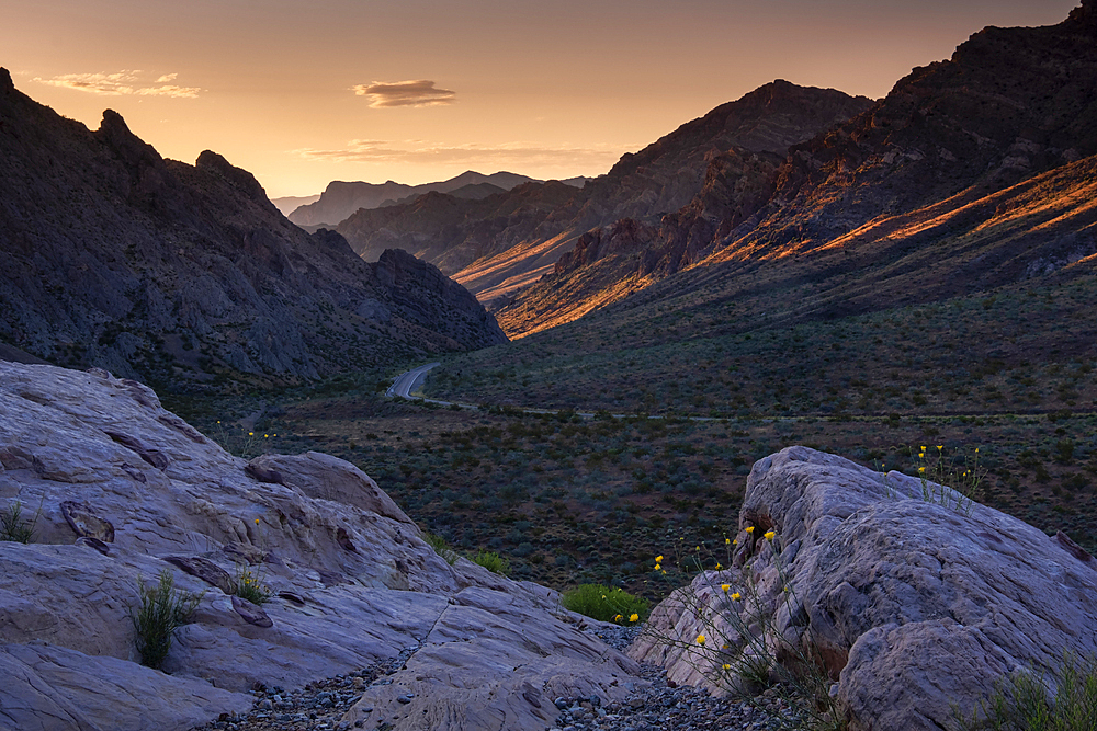 Sunrise illuminates the pass through the mountains at the western entrance to the Valley of Fire State Park, Nevada, United States of America, North America