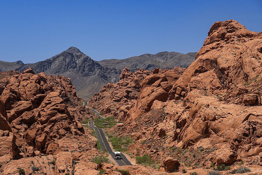 An RV Camper Van Recreational Vehicle travels the highway of Mouse's Tank Road through the Valley of Fire State Park, Nevada, United States of America, North America