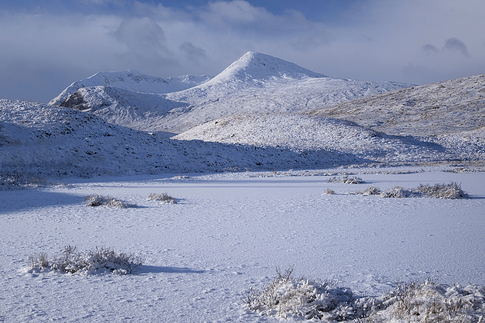 Frozen unnamed Lochan on Rannoch Moor looking to Meall a Bhuiridh and Clach Leathad, Rannoch Moor in winter, Argyll and Bute, Scottish Highlands, Scotland, United Kingdom, Europe