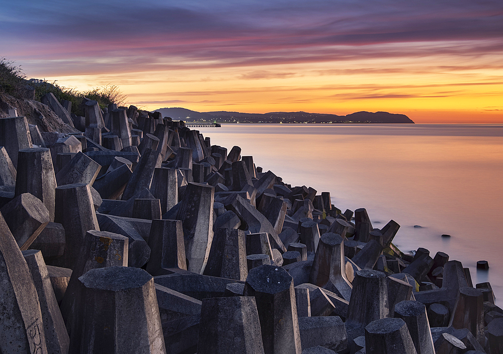 Sea Defences on Llanddulas Beach backed by The Great Orme at sunset, Llanddulas, near Abergele, Conwy County Borough, North Wales, UK