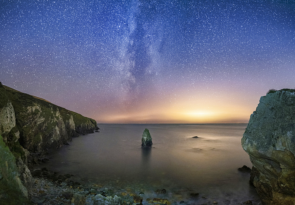 The Milky Way and Starry night sky over Gwenfaen’s Pillar, Porth Saint, near Rhoscolyn, Anglesey, North Wales, UK