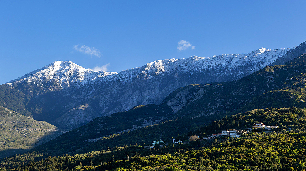 Snow capped peaks including Mount Cika rising above hillside village, Palase, near Dhermi, Albania, Europe