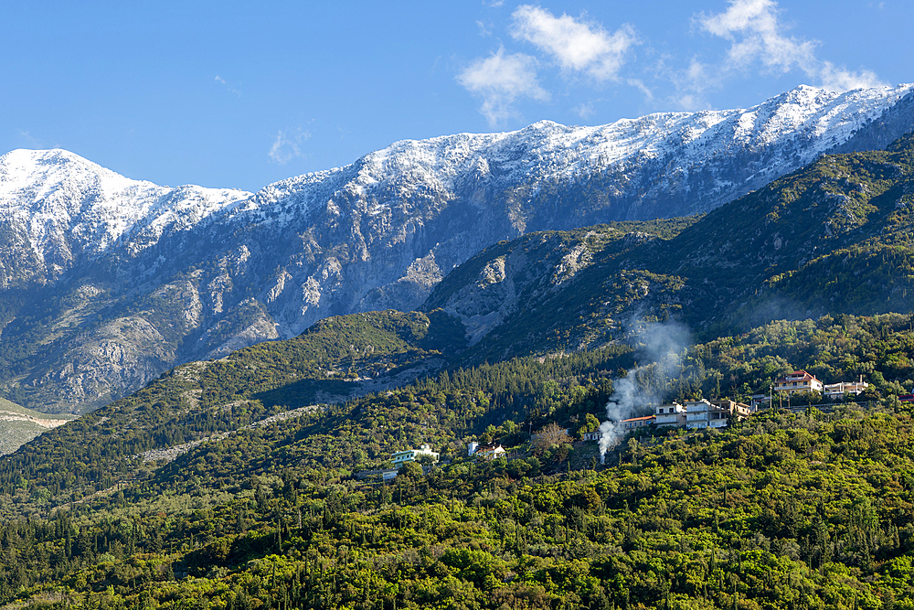 Snow capped peaks including Mount Cika rising above hillside village, Palase, near Dhermi, Albania, Europe