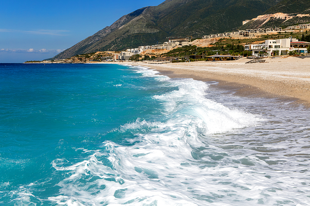 Ionian Sea, Drymades Beach, with large scale tourist development construction building work in the distance, Albanian Riviera, Dhermi, Albania, Europe