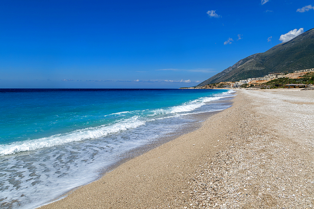 Ionian Sea, Drymades Beach, with large scale tourist development construction building work in the distance, Albanian Riviera, Dhermi, Albania, Europe