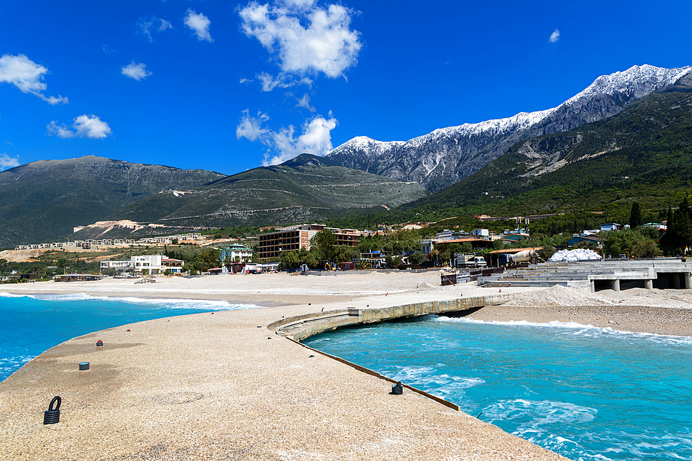 Tourist development construction building work view from Drymades Beach to Mount Cika snow capped mountain range, Dhermi, Albanian Riviera, Albania, Europe