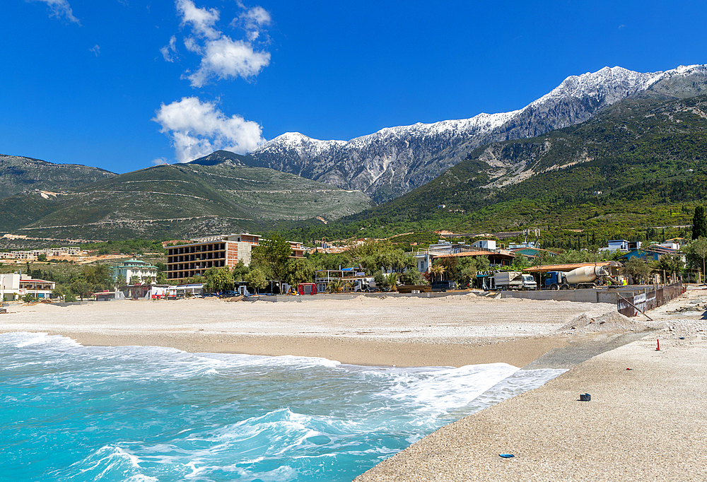 Tourist development construction building work view from Drymades beach to Mount Cika snow capped mountain range, Dhermi, Albanian Riviera, Albania, Europe