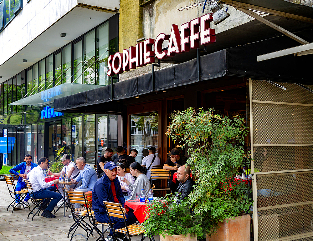 People sitting on street outside city centre cafe, Sophie Caffe, Tirana, Albania, Europe