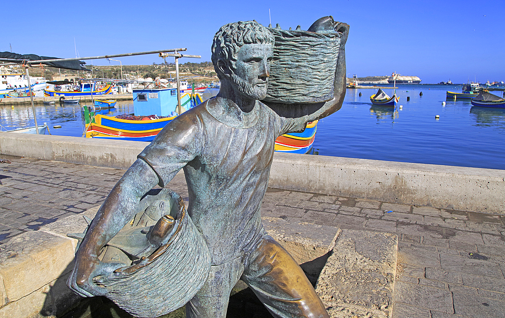 Fisherman statue sculpture in harbour at fishing village of Marsaxlokk, Malta, Mediterranean, Europe