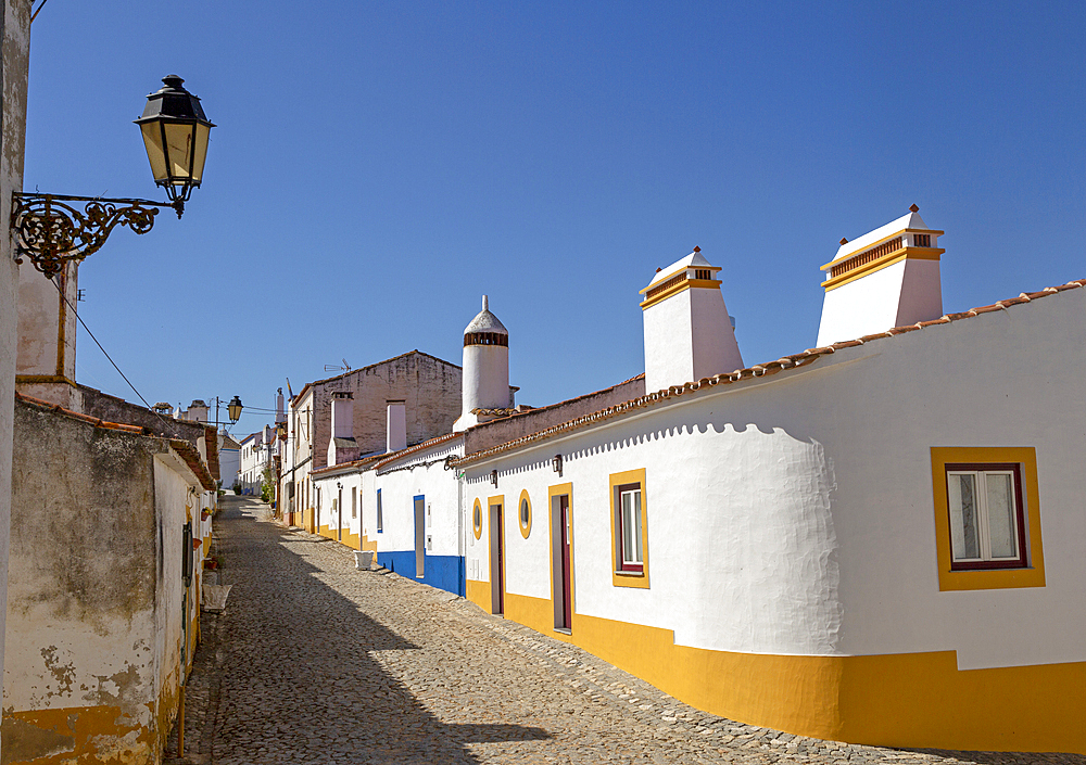 Traditional architecture with large chimneys on whitewashed houses and street in the small rural settlement village of Terena, Alentejo Central, Portugal, Europe