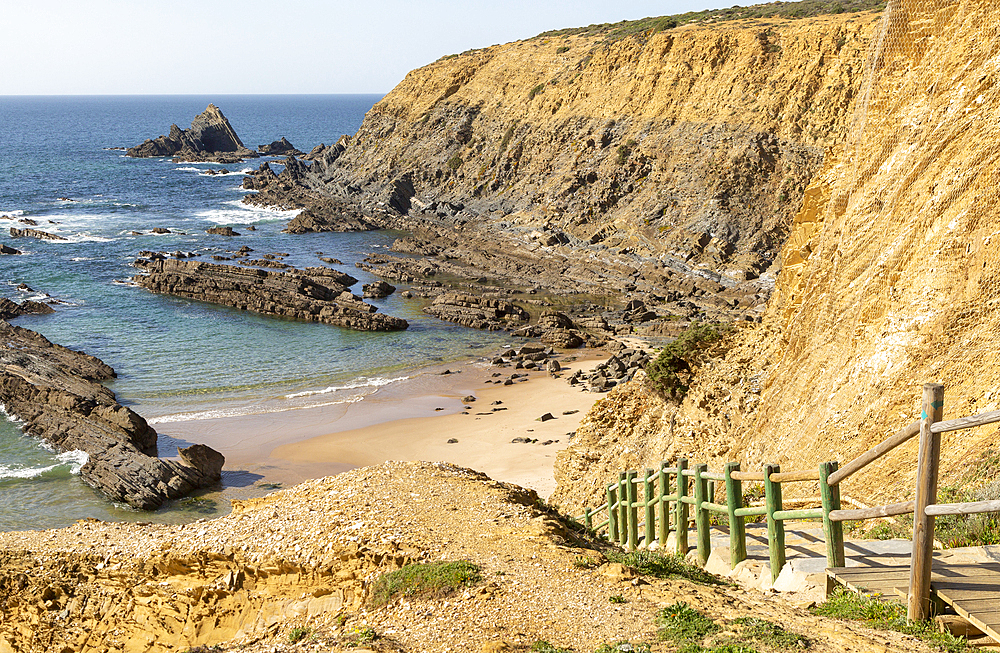 Rocky coastal landscape of Praia dos Alteirinhos beach in bay with rocky headland part of Parque Natural do Sudoeste Alentejano e Costa Vicentina, Zambujeira do Mar, Alentejo Littoral, Portugal, Europe