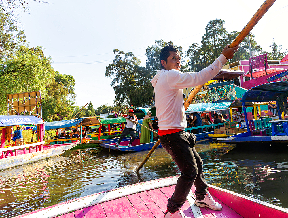 Popular tourist attraction, people boating on colourful barges on canal at Xochimiloco, Mexico City, Mexico, North America