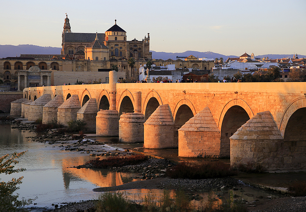 Roman bridge spanning river Rio Guadalquivir with Mezquita buildings, Cordoba, Spain