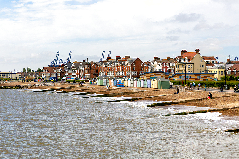 Old concrete groynes on beach with beach huts, Felixstowe, Suffolk, England, UK