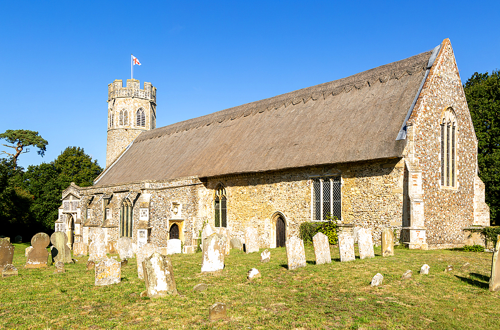 Churchyard gravestones thatched parish church of St Peter, Theberton, Suffolk, England, UK