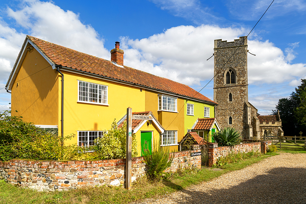 Historic cottages next to village parish church of All Saints, Rede, Suffolk, England, UK