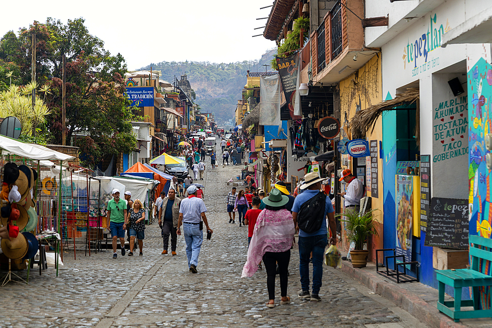 People walking along busy shopping street with mountain in distance, Tepoztlan, State of Morelos, Mexico, North America