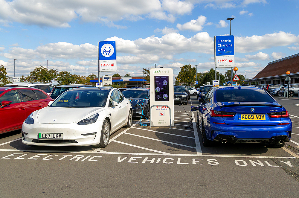 Electric vehicles charging Pod Point, Tesco Extra supermarket carpark, Swindon, Wiltshire, England, UK