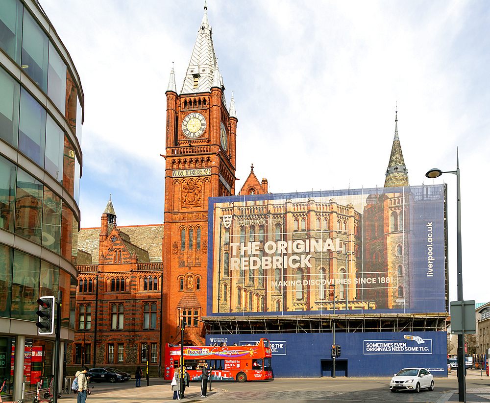 Victoria building clocktower renovation of art gallery, University of Liverpool, England, UK - red double-decker tour bus passing