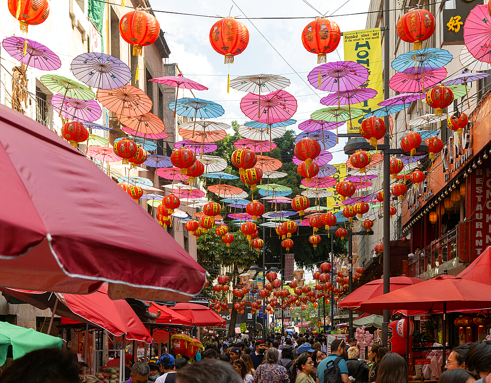 Red paper Chinese lanterns and umbrellas hanging above the street advertising various restaurants, in Chinatown, Mexico City, Mexico, North America