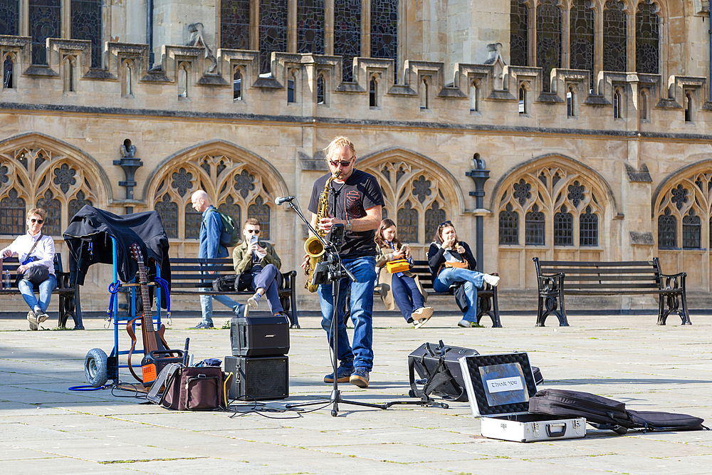 Busker musician performing in Bath Abbey church yard, city of Bath, north east Somerset, England, UK