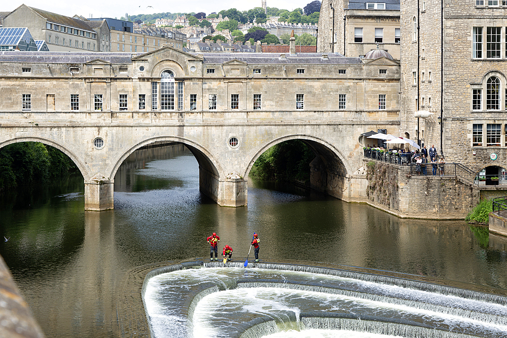 Avon Fire and Rescue Service personnel on weir on River Avon, Pulteney Bridge, city of Bath, north east Somerset, England, UK