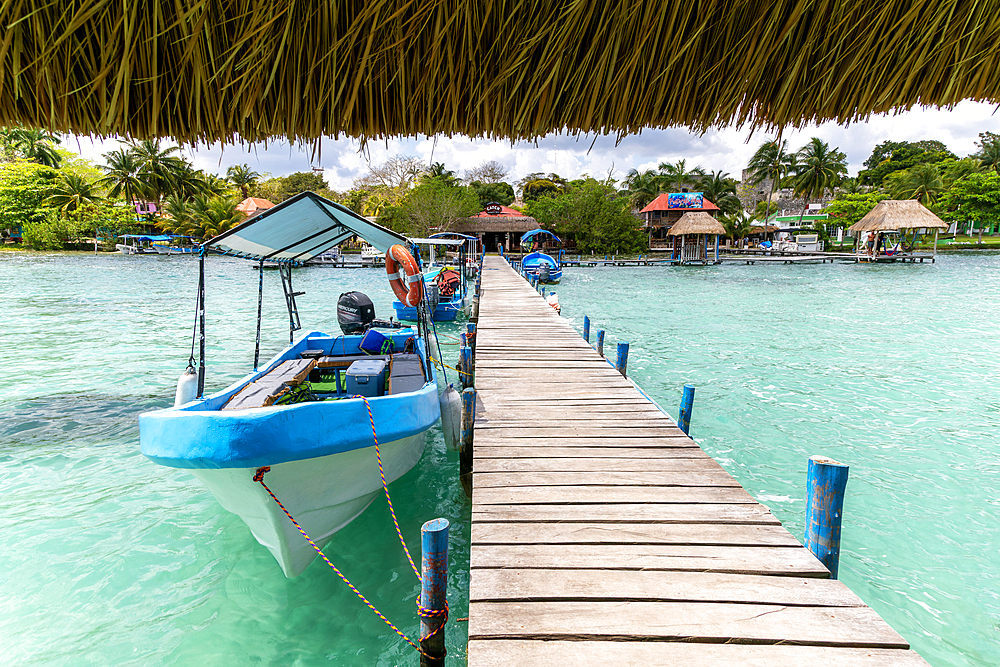 Boats moored on wooden jetty leading to land on Lake Bacalar, Bacalar, Quintana Roo, Yucatan Peninsula, Mexico, North America