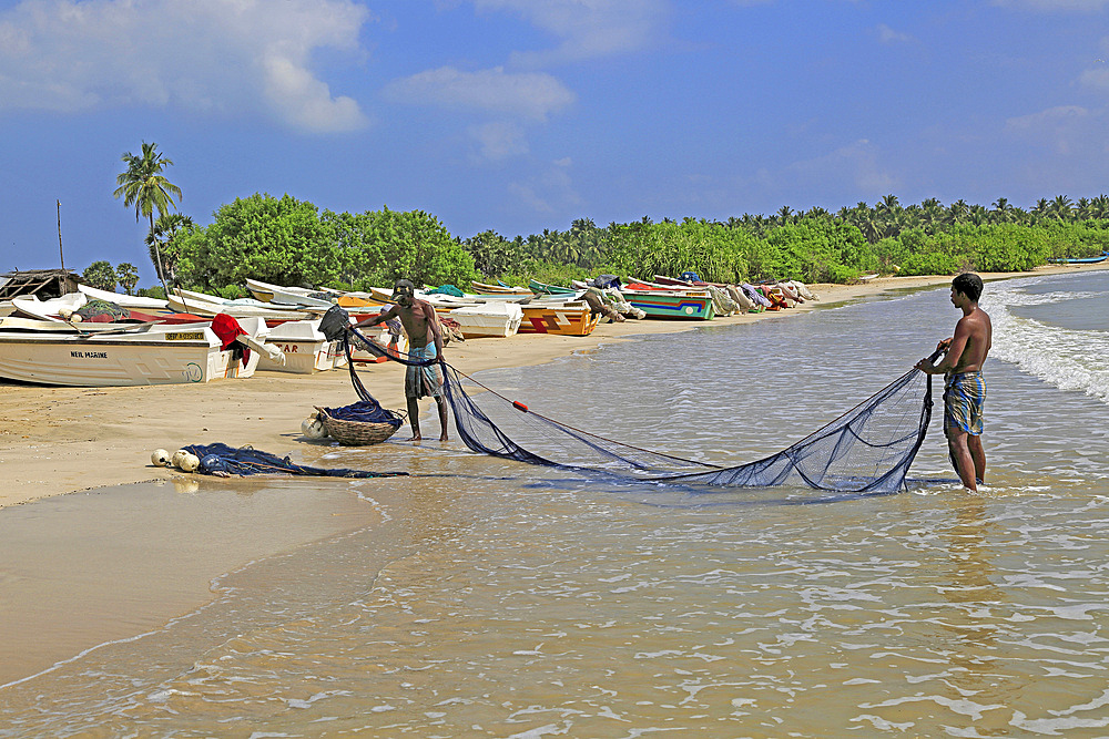 Men with fishing nets on tropical beach at Pasikudah Bay, Eastern Province, Sri Lanka, Asia