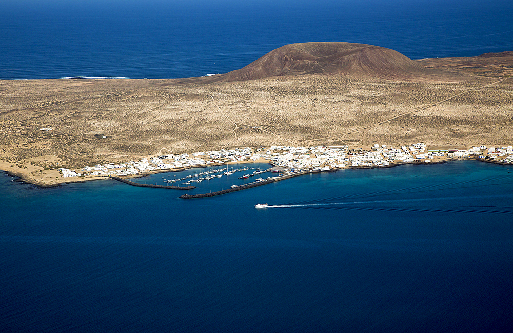 View from Mirador del Rio of ferry ship approaching Caleta del Sebo, La Graciosa island, Lanzarote, Canary Islands, Spain, Atlantic, Europe