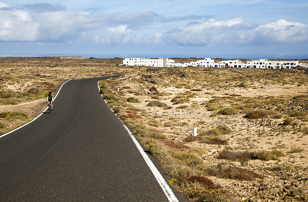 Cyclist on road at Caleta de Caballo village, Lanzarote, Canary islands, Spain, Atlantic, Europe