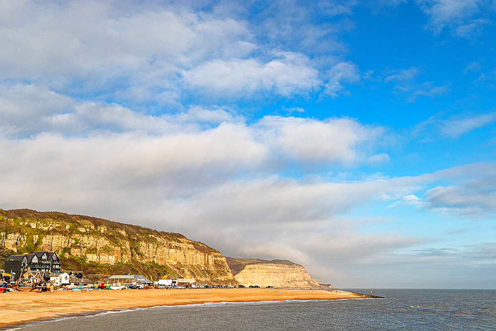 Scenic coast with sandy beach, cliffs, and blue sky with clouds, Hastings, East Sussex, England, United Kingdom, Europe