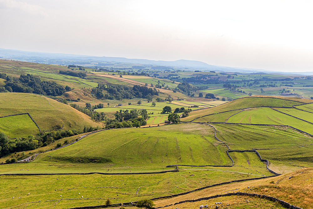 Rolling hills with patchwork fields under a hazy sky, depicting rural farmland and natural beauty, North Yorkshire, England, United Kingdom, Europe