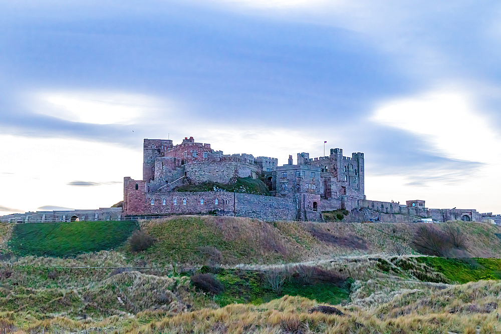 Majestic medieval castle on a hill with cloudy sky at dusk, showcasing historical architecture, Northumberland, England, United Kingdom, Europe