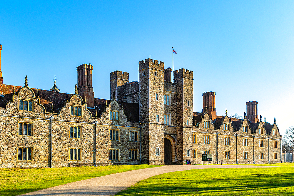 Historic stone castle with towers and battlements under a clear blue sky, surrounded by greenery, Surrey, England, United Kingdom, Europe