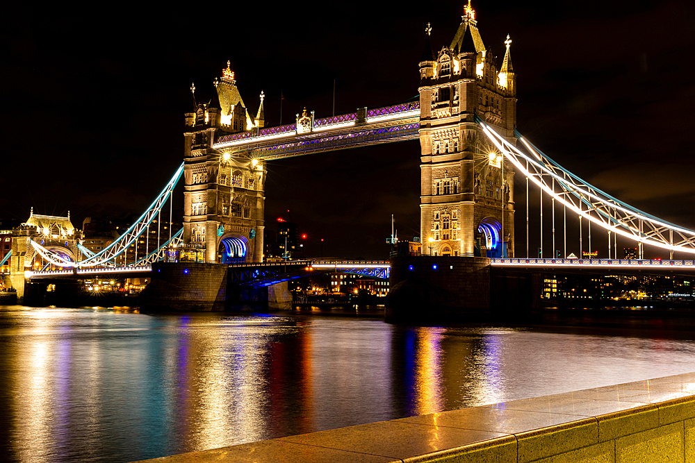 Illuminated Tower Bridge in London at night with reflections on the River Thames, London, England, United Kingdom, Europe