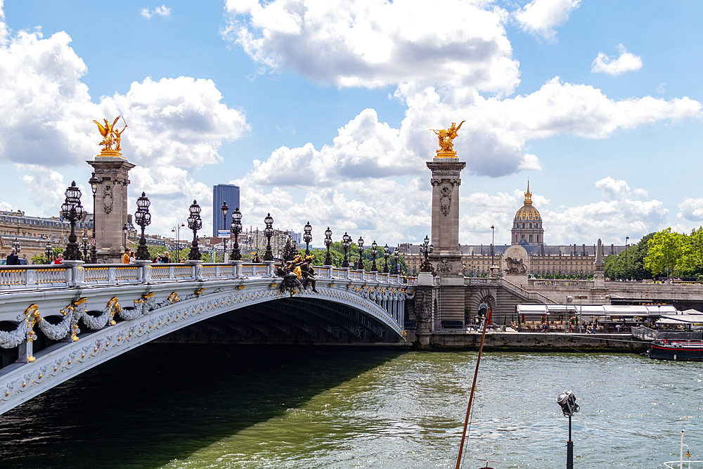 Scenic view of the Pont Alexandre III bridge over the Seine River with ornate sculptures and the Parisian skyline in the background, Paris, France, Europe