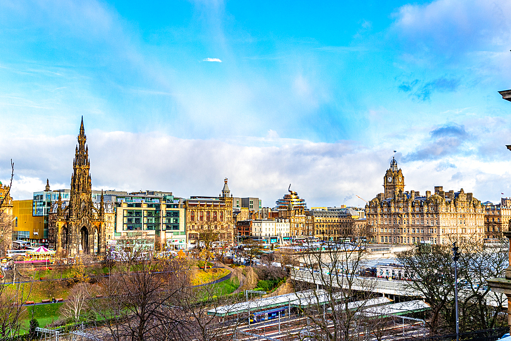 Panoramic view of a historic cityscape with a prominent monument and classical architecture under a blue sky with clouds, Edinburgh, Scotland, United Kingdom, Europe