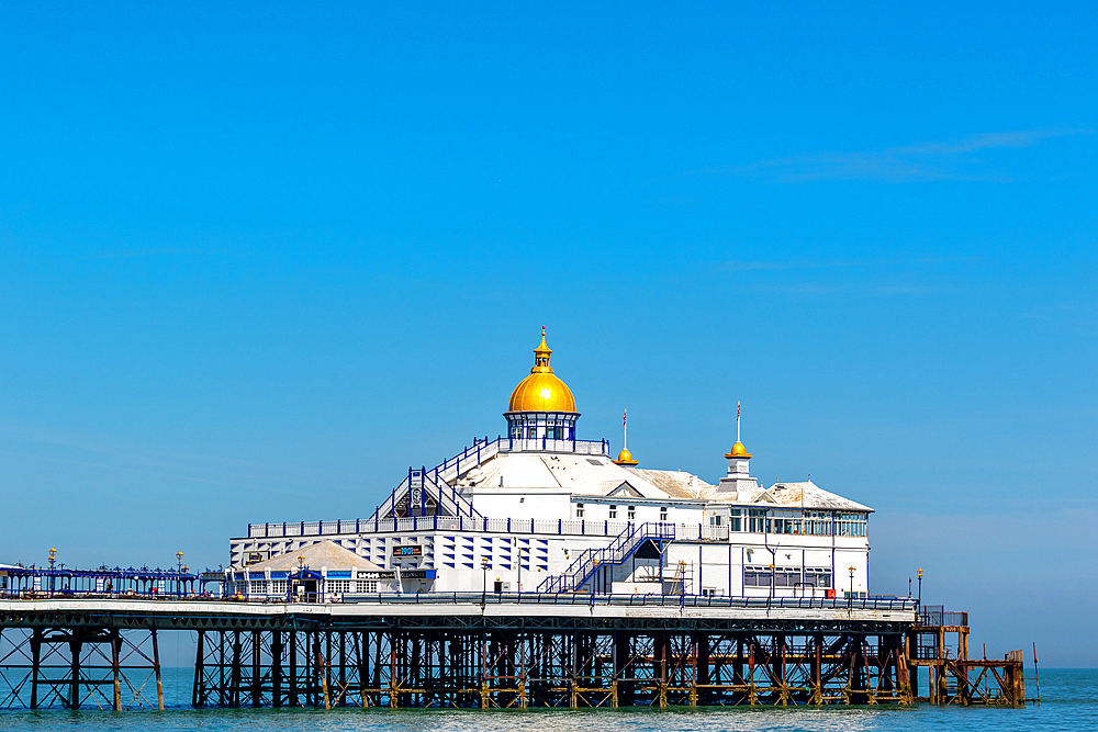 Victorian pier with a golden dome against a clear blue sky, symbolizing classic British seaside architecture, Eastbourne, East Sussex, England, United Kingdom, Europe