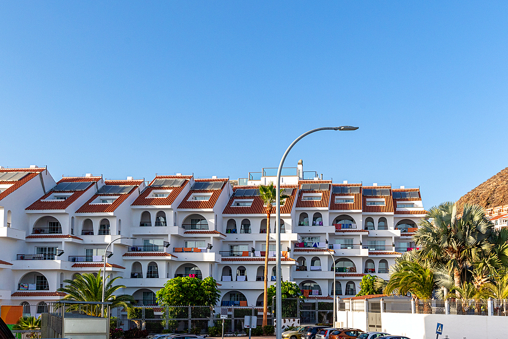 White residential building with balconies under clear blue sky in Los Cristianos, Tenerife, Canary Islands, Spain, Atlantic, Europe