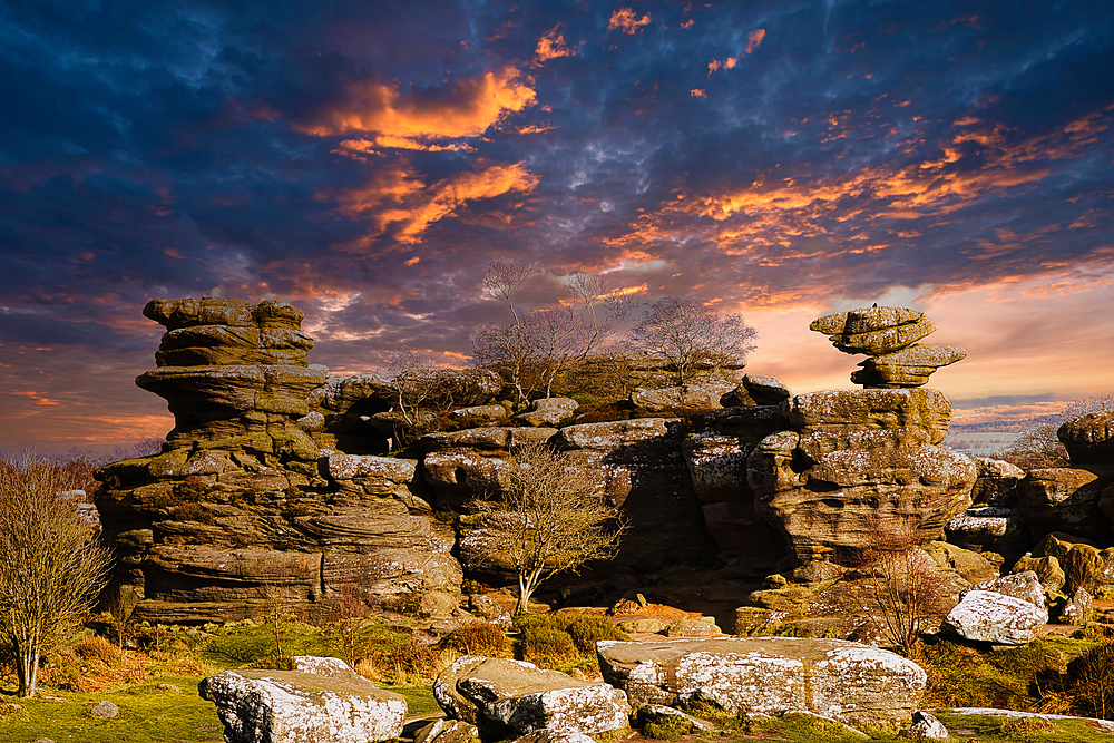 Dramatic sky at sunset over rugged rock formations in a serene landscape at Brimham Rocks, in North Yorkshire