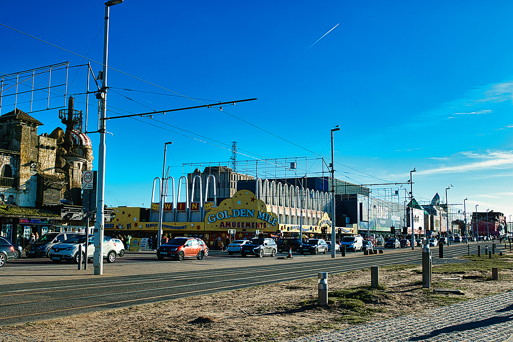 Urban street scene with cars and eclectic architecture under a clear blue sky in Blackpool, England