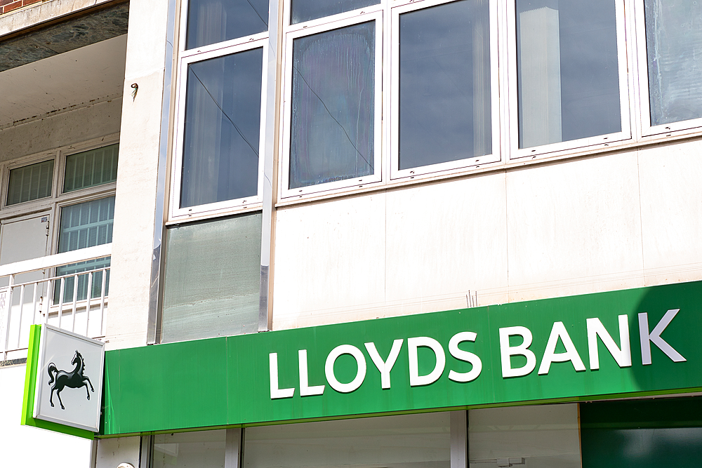 A partial view of a Lloyds Bank building, featuring the sign, windows, and adjacent building detail in daylight in Kingston, UK.