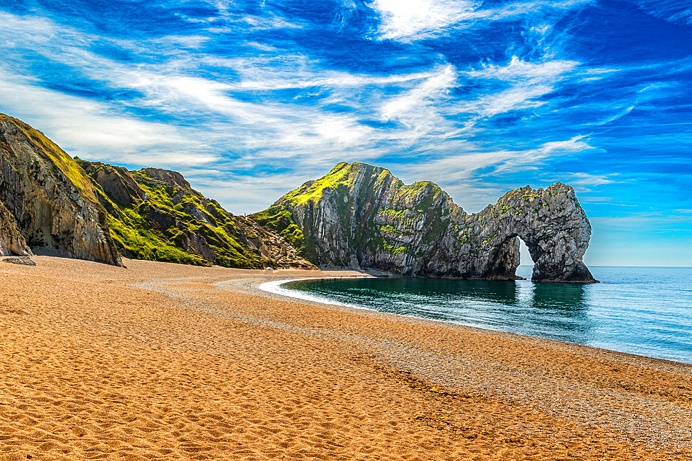 Scenic view of a beach with a large rock formation, clear blue sky, and calm sea at Durdle Door, Jurassic Coast, UNESCO World Heritage Site, Dorset, England, United Kingdom, Europe