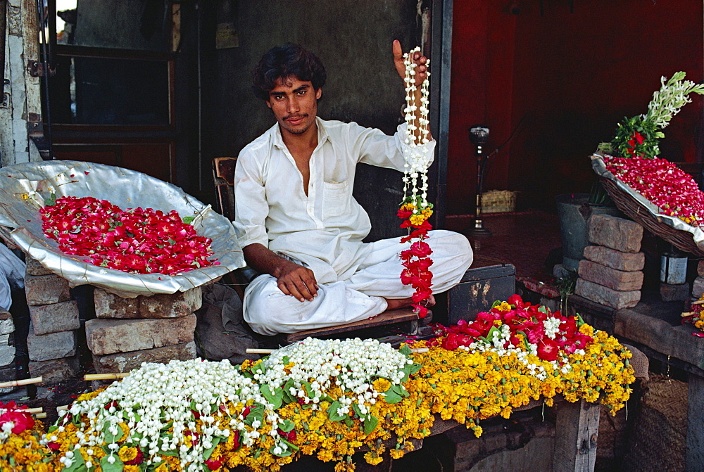 Portrait of a man selling garlands of flowers in the flower market in Lahore, Punjab, Pakistan, Asia