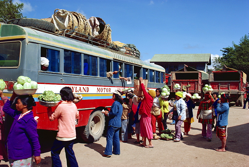 Groups of people loading vegetables and bags onto a public bus in a bus station in the Mountain Province region of the Philippines, Southeast Asia, Asia