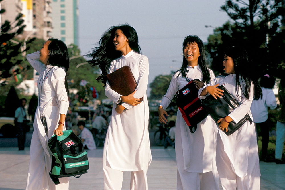 School girls facing Ho Chi Minh statue, Ho Chi Minh City (Saigon), Vietnam, Indochina, Southeast Asia, Asia