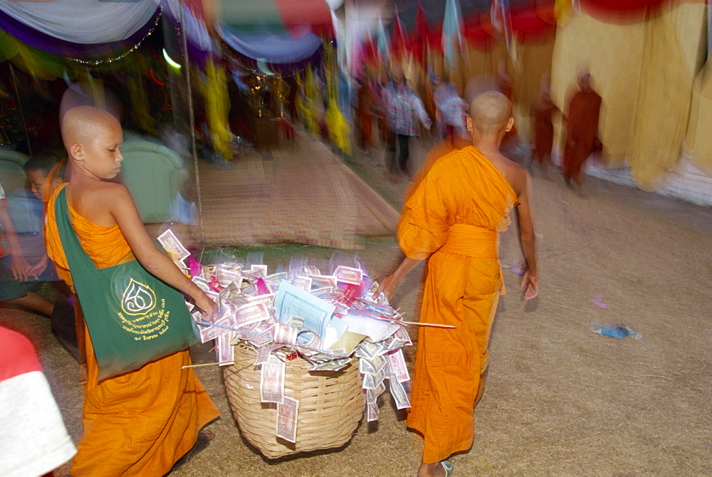 Two young monks carrying basket of donations during the Pha That Luang Festival during Buddhist Lent, at the Great Stupa in Vientiane, Laos, Indochina, Southeast Asia, Asia